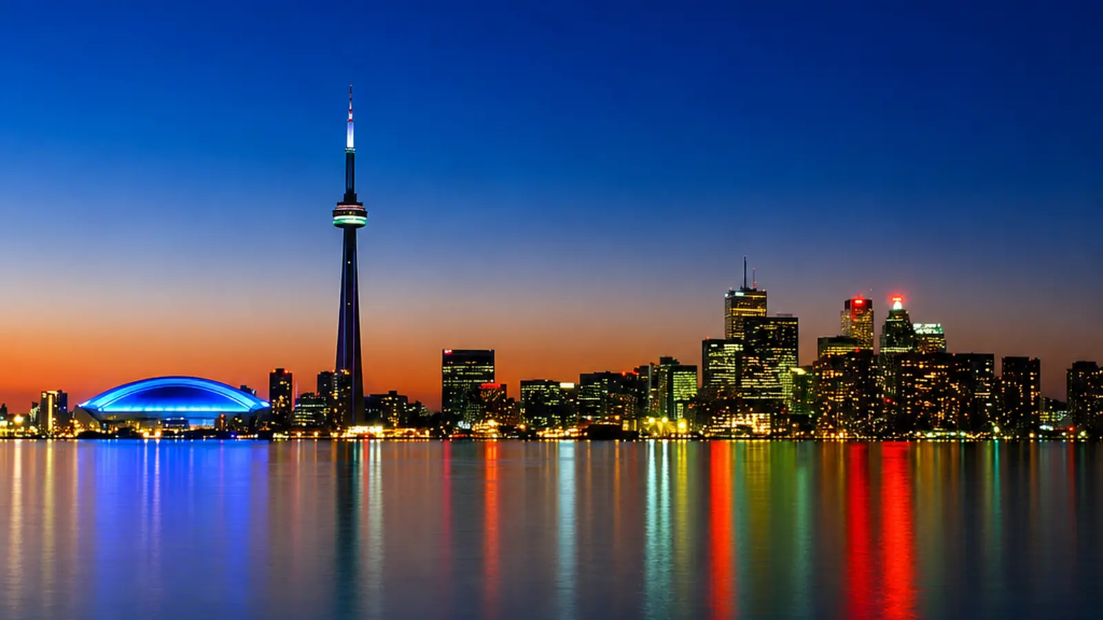 Toronto skyline at dusk with the illuminated CN Tower and waterfront